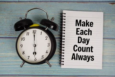 Make Each Day Count Always text written on notepad with alarm clock on wood.. Stock Photos