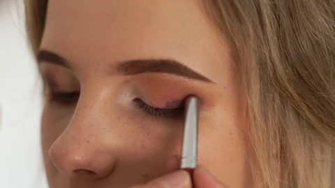 Make up eyes with eye shadows close up. Visagiste using cosmetic brush for Stock Footage 100700940