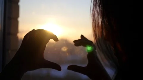 Make of fingertips romantic heart, against the backdrop of a beautiful sunset Stock Footage 72408937