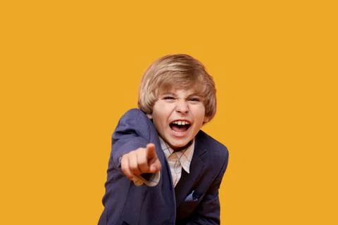 Make fun and point your finger at the camera. The little boy is laughing. Stock Photos