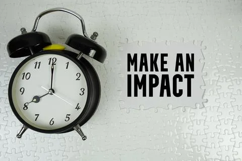 Make An Impact text with alarm clock on white background Stock Photos