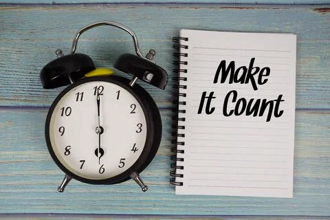 Make It Count text written on notepad with alarm clock on wooden background Stock Photos