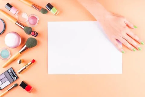 Make up items on orange. Flat lay with blank card Stock Photos