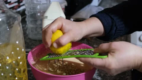 Make lemon cake by grating lemon zest in your kitchen. Vídeo Stock 147508816