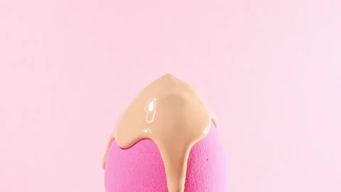 Make-up liquid beige foundation pouring on sponge, closeup. Cosmetic Dripping bb Stock Footage 167893583
