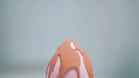 Make-up liquid beige foundation pouring on sponge, closeup. Cosmetic Dripping bb Video stock 224757421