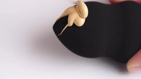 Make-up liquid beige foundation pouring on black sponge, closeup. BB Cream .. Stock Footage 257467242