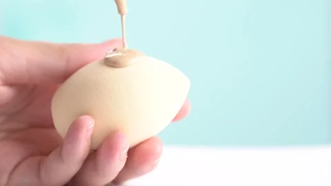 Make-up liquid beige foundation pouring on sponge, closeup. BB Cream drippi.. Stock Footage 277976293