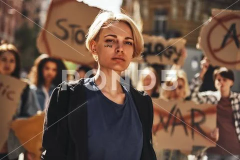 Make love. Young blonde woman with word love written on her face protesting with Stock Photos