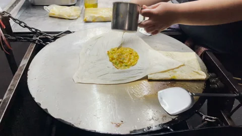 Make Mataba Roti with Flour and Eggs on a Hot Pan Stockbeeldmateriaal 168966822