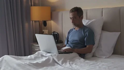 Make mistake typing on laptop aghast holding head while lying on the bed Video stock 230748183