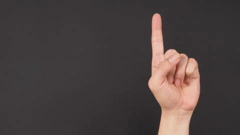 Make model is doing one finger or point up hand sign on black background. Stock Photos