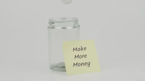 Make More Money text or word on yellow notes on empty jar hand insert coin Stock Footage 307083455