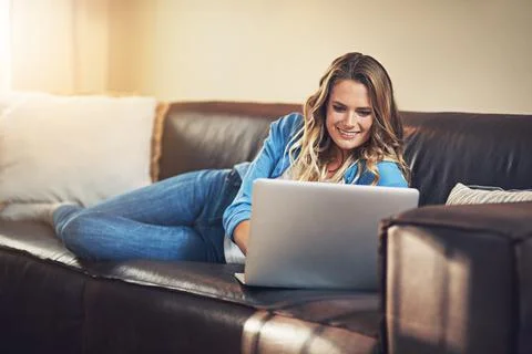 Make more time for yourself. a relaxed young woman using a laptop on the sofa at 스톡 사진