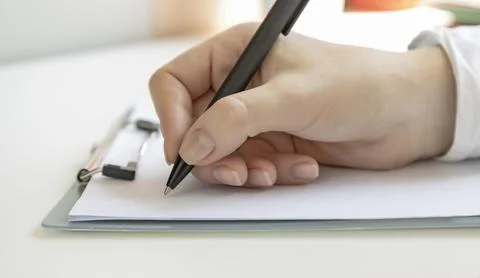 Make a note, female hand holding a pen, ready to write something on a blank Stock Photos