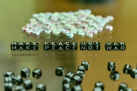 MAKE PEACE NOT WAR  written with Acrylic Black cube with white Alphabet Beads Foto stock