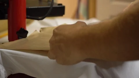 Make a print on t-shirts. The operator puts a t-shirt under the press, imposes a Stock Footage 92498636