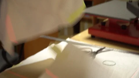 Make a print on t-shirts. The operator puts a t-shirt under the press, imposes a Stock Footage 92498748