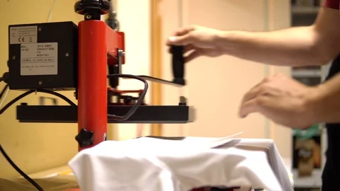 Make a print on t-shirts. Press presses the t-shirt and makes a picture on it. T Stock Footage 92498479