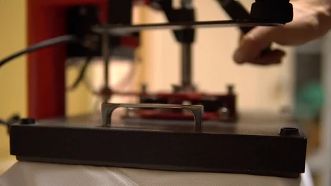 Make a print on t-shirts. The press rises, the person removes the stencil and Stock Footage 92498536