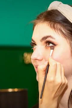 Make-up in the process. The hand of the makeup artist applies eye shadow under Stock Photos