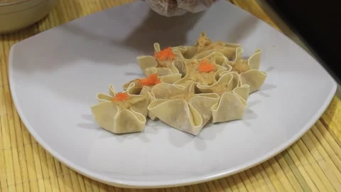 Make processed dimsum. someone makes a plate of dimsum Stock Footage 334647392
