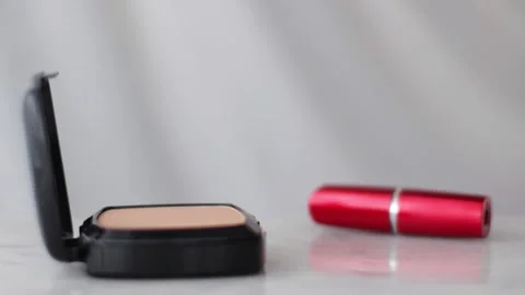 Make-up products on marble table, powder, lipstick and brush as background for Stock Footage 135132193