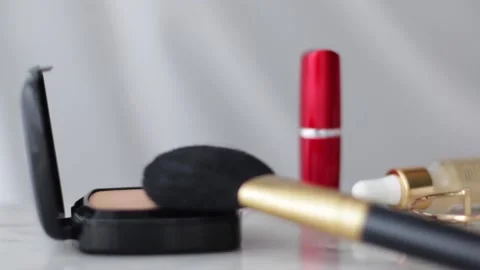 Make-up products on marble table, powder, lipstick and brush as background for Stock Footage 139682172