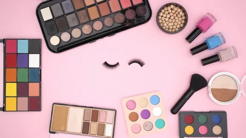 Make up products on pink background and eyelashes blinking - Stop motion Stock Footage 106320299