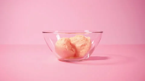 Make scoop of mango ice cream with a special spoon on pink background Stock Footage 152034256