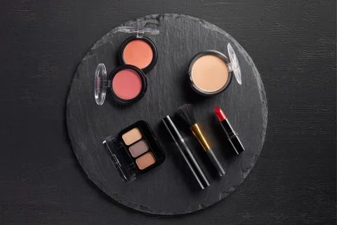 Make up set with eye shadows and blush on round slate background Stock Photos