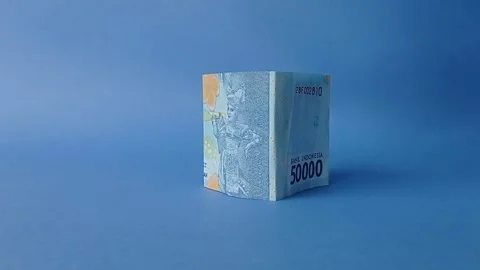 Make a small house with two pieces of five thousand rupiah with a blue backgroun Stock Footage 151025084