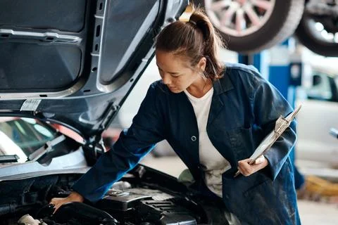 Make sure your car is up-to-date with its maintenance. a female mechanic working Foto stock