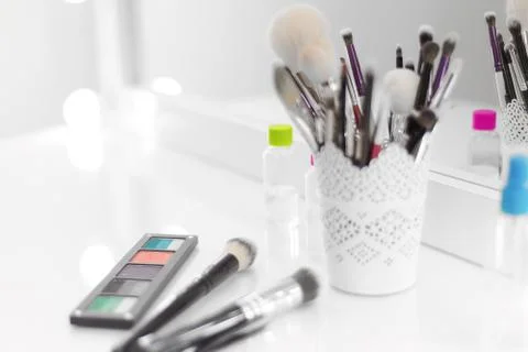 On the make-up table are makeup brushes, a palette with shadows Stock Photos