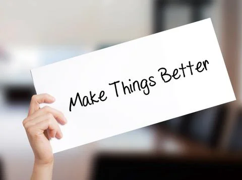 Make Things Better Sign on white paper. Man Hand Holding Paper with text. Iso Foto stock