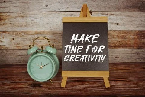 Make Time For Creativity text on easel blackboard with alarm clock on woode.. Stock Photos