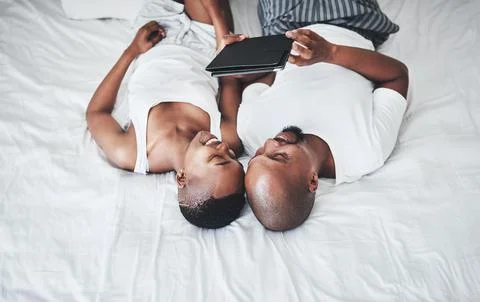 Make time to keep that connection. a happy young couple using a digital tablet Stock Photos