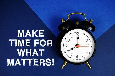 Make Time For What Matters! text with alarm clock on blue background Stock Photos