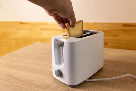 To make toast, bread is loaded into an electric Stock Photos