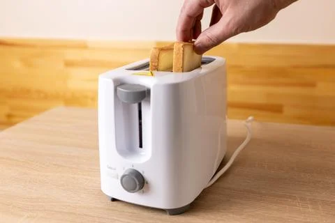 To make toast, bread is loaded into an electric Stock Photos