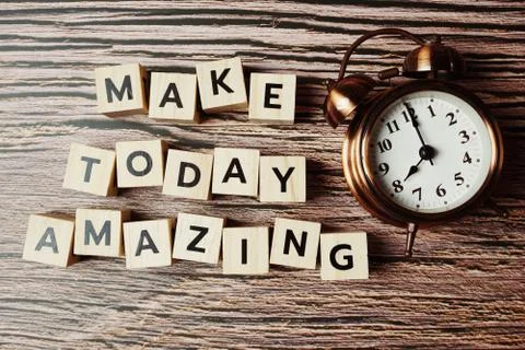 Make Today Amazing alphabet letter with alarm clock on wooden background Stock Photos