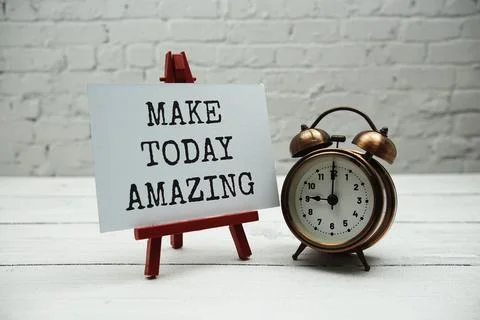 Make today amazing text and alarm clock on white brick wall and wooden back.. Stockfoto's