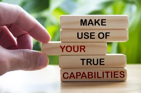 Make use of your true capabilities text on wooden blocks with hand and blur.. Stock Photos