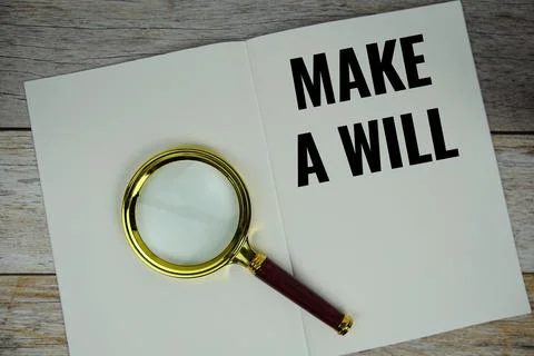 Make a will text on note page with magnifying glass top view on wooden back.. Stock Photos