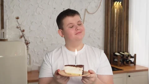 Make a wish. Man wearing party cap blowing out burning candles on birthday cake Stock Footage 262076604