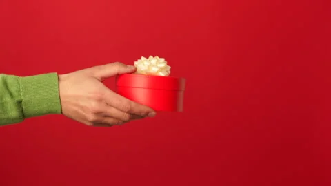 Make your love happy. Close up of hands of guy giving a gift with ribbon to his Stock Footage 146127244