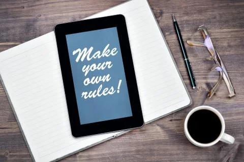 Make your own rules! Text on tablet device on a wooden table 스톡 사진