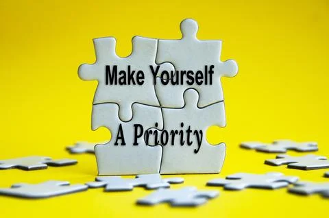 Make yourself a priority text on jigsaw puzzle with yellow background. Stock Photos