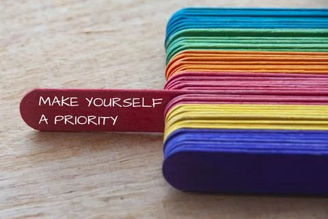 Make yourself a priority text on red wooden stick sticking out - Inspiratio.. Stock Photos