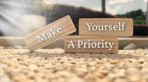 Make yourself a priority text on wooden blocks with bright sun and park Stock Photos